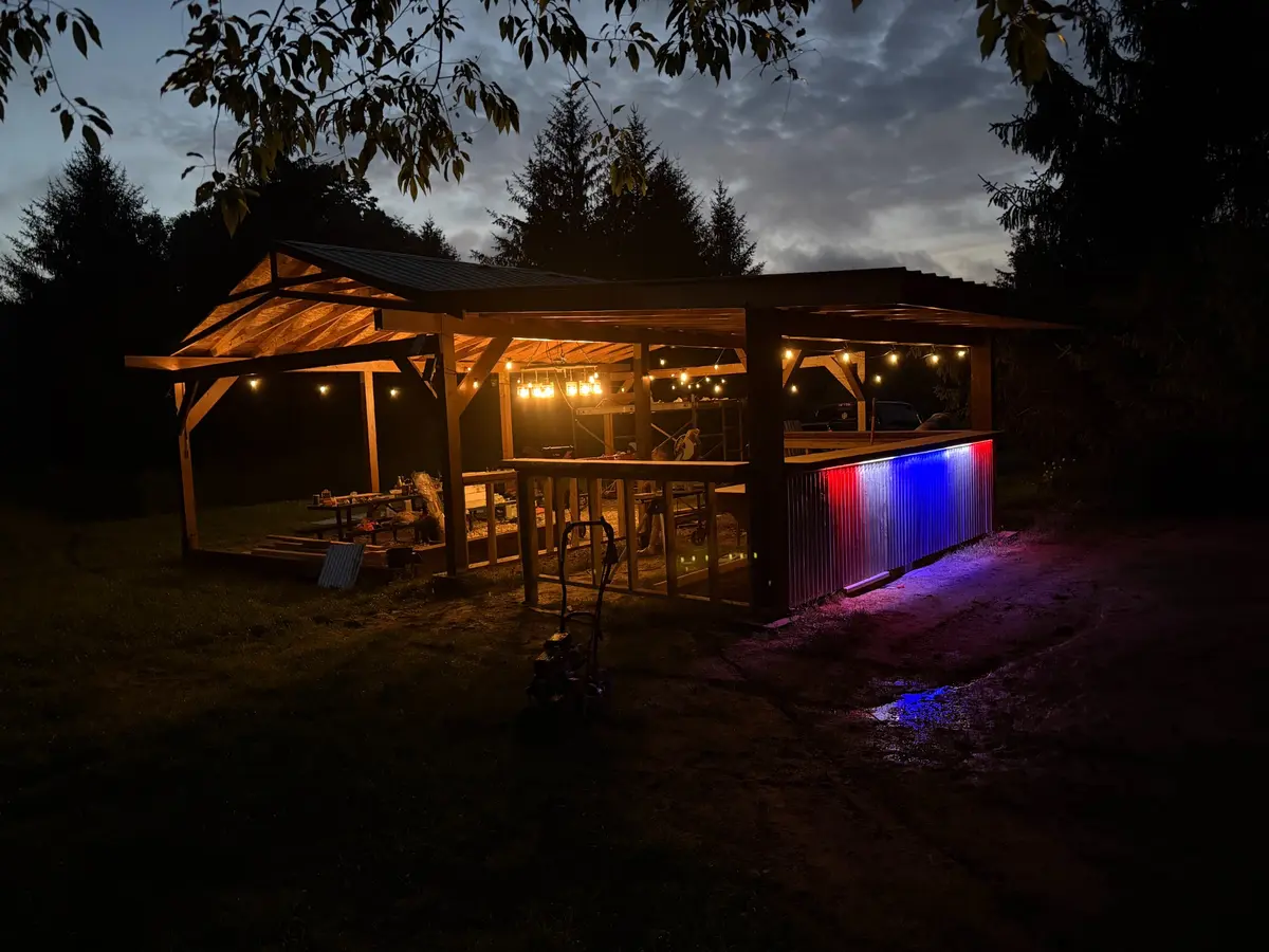 The open-air pavilion and bar lit at night at Halo Hills